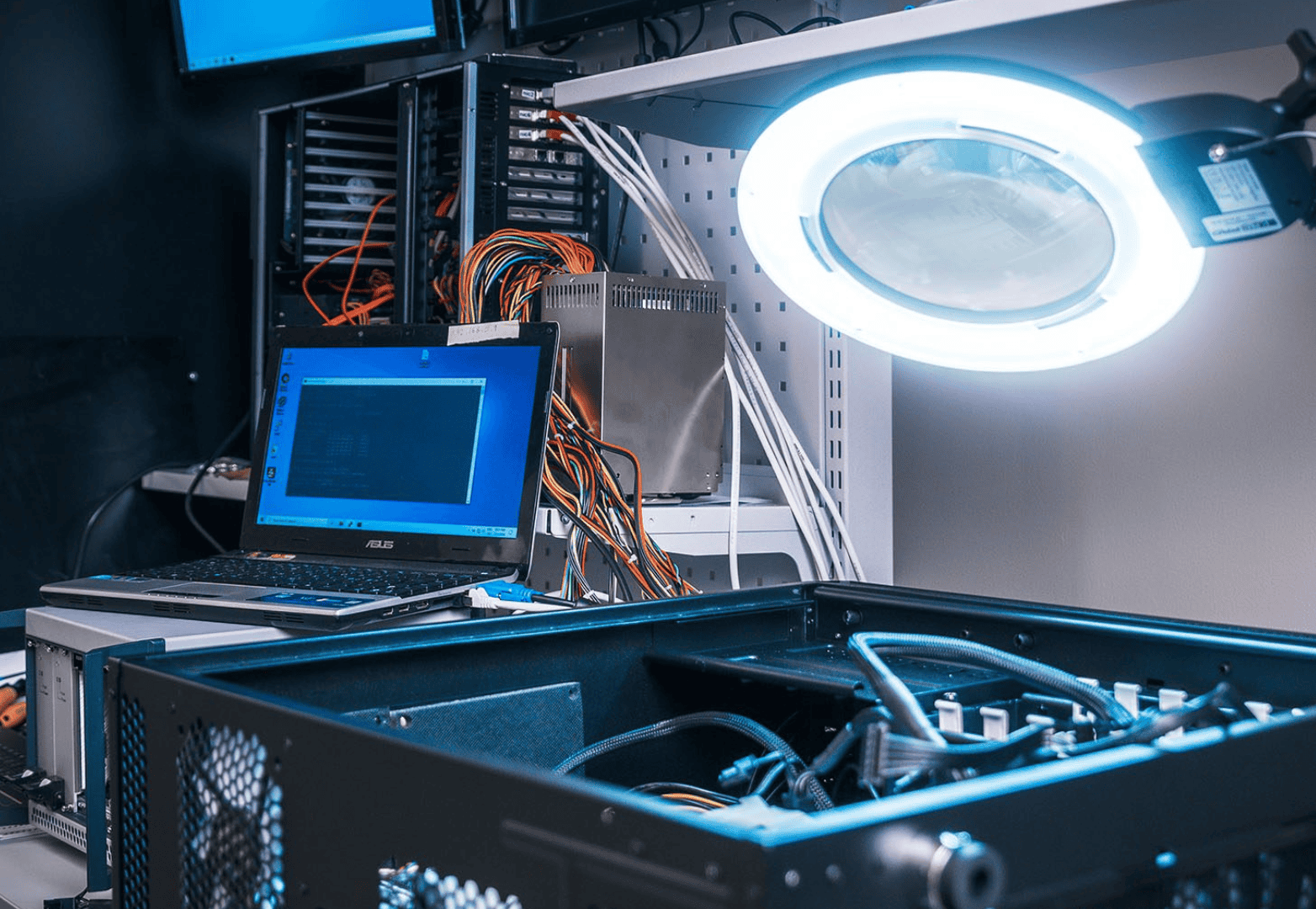 Server rack with networking hardware and a laptop illustrating web hosting and server management.