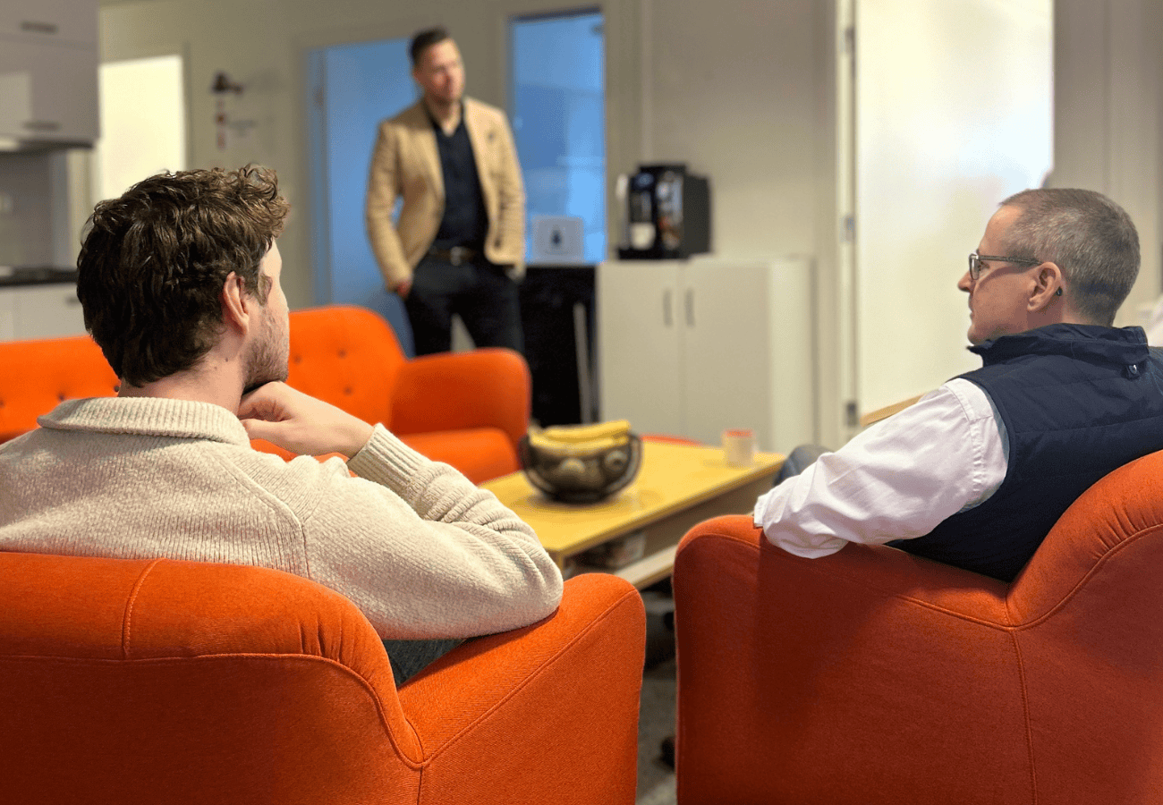 Modern office meeting with colleagues discussing ideas casually.