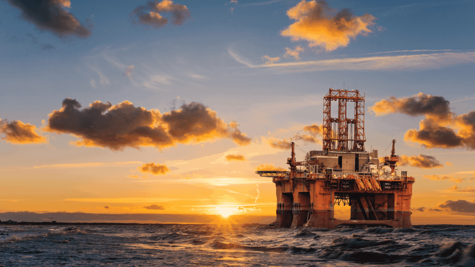 Offshore oil rig during sunset with dramatic clouds and ocean waves, showcasing energy infrastructure in marine environment, ideal for oil and energy industry visuals.